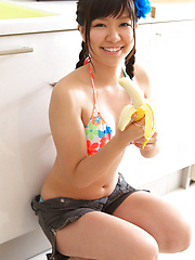 Sweet Ayana Tanigaki smiles and poses at the kitchen with banana - Erotic and nude pussy pics at GirlSoftcore.com